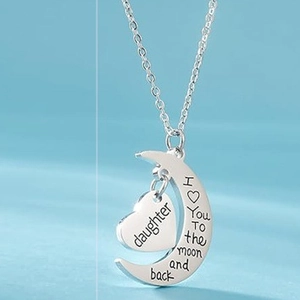 Detail of silver moon and heart necklace with engraved I love you to the moon and back text