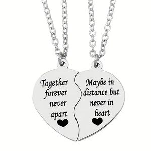 Detail of puzzle heart necklaces with engraved quotes on polished stainless steel