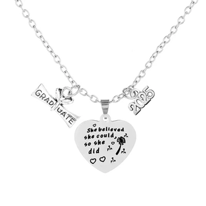 Macro detail of silver graduation necklace with 2025 charm and engraved heart pendant