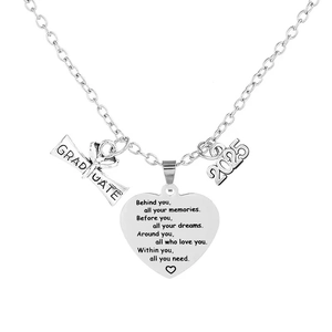 Macro view of silver graduation heart pendant with 2025 charm and engraved quote