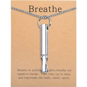Close-up of a silver cylinder whistle pendant on a box chain for mindful breathing