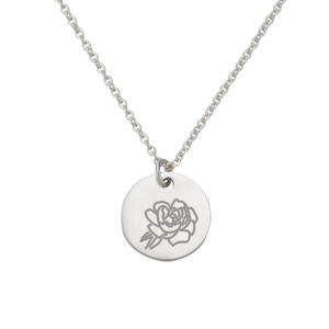 Dettaglio della collana in argento con ciondolo a disco e incisione floreale di una rosa