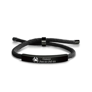 Dettaglio del bracciale intrecciato nero segno Cancro con piastra metallica incisa