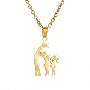 Close-up of golden family necklace featuring mother and daughters holding a heart pendant
