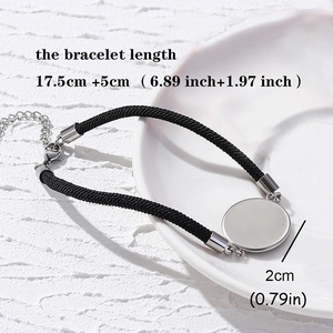 Adjustable black woven bracelet with round stainless steel plate on ceramic dish