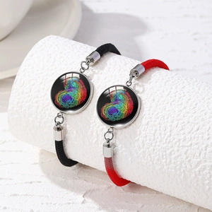 Close-up of black and red braided bracelets with colorful heart fingerprint charms