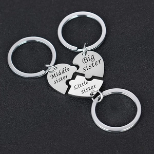 Détail de trois porte-clés puzzle en forme de cœur imbriqués pour trois sœurs
