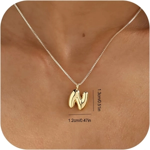 Detailansicht der goldenen Buchstaben-N-Kette am Model mit Größenangaben in Zentimetern