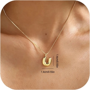 Nahaufnahme einer polierten 18K Gold Bubble Buchstaben U Kette, getragen von einem Model