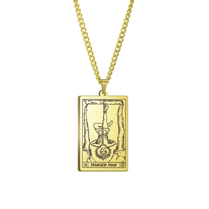 Detail eines goldenen Tarot-Anhängers mit dem Motiv Der Gehängte auf einer quadratischen Platte