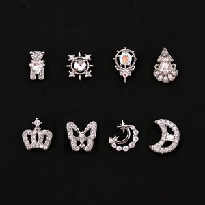 Macro shot of 8 silver piercing studs with rhinestones including heart bear and crown
