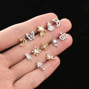 Detailed shot of assorted mini stud earrings with butterfly, crown, and moon shapes