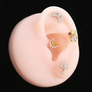 Close-up of geometric diamond earrings set including moon, star, and flower designs