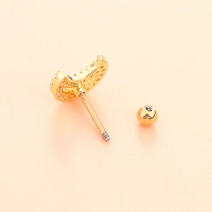 Macro shot of gold crescent moon stud with zircons and threaded screw ball back