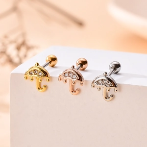 Vue macro de boucles d'oreilles parapluie avec zircons en or, or rose et argent poli
