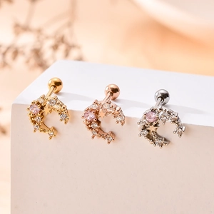 Détails macro de piercings cartilage lune et étoile avec zircon en or, rose et argenté