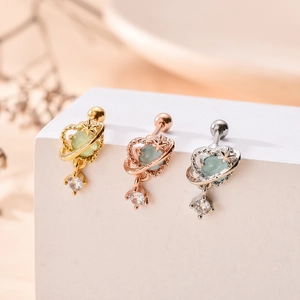 Trois boucles d'oreilles cœur et étoile en or, argent et or rose sur support d'expo