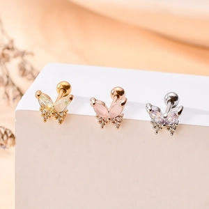 Detailed macro shot of butterfly ear studs in gold, rose gold and silver with cubic zirconia
