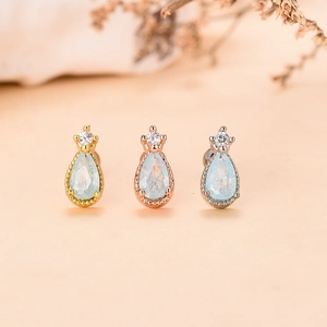 Dettaglio dei orecchini vintage a goccia in oro, oro rosa e argento con zirconi