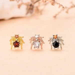 Dettaglio degli orecchini a forma di ragno con zirconi in oro, argento e oro rosa