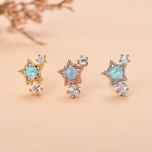 Dettaglio di orecchini a stella con opale blu e zircone brillante in tre tonalità di metallo