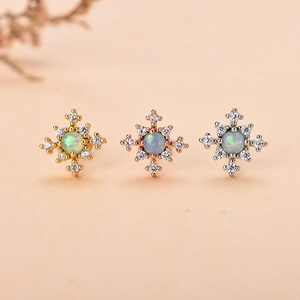 Dettaglio di orecchini a stella con opale e zirconi in oro, argento e oro rosa