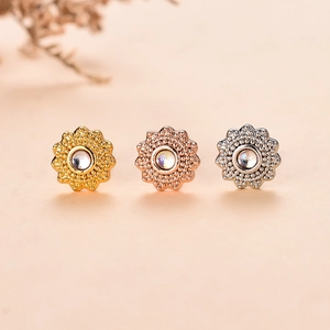 Vista macro degli orecchini a fiore con cristalli in oro, oro rosa e argento
