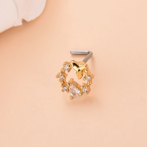 Detailed view of a gold-plated nose stud with zircon-inlaid fish tail design