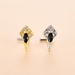 Dettaglio di piercing naso vintage a forma di scudo con zircone nero e incisione