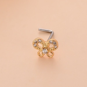 Détail macro du piercing de nez en acier inoxydable doré avec papillon en zircon étincelant