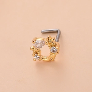 Vue macro d'un piercing de nez en L avec couronne de fleurs dorées et oxydes de zirconium