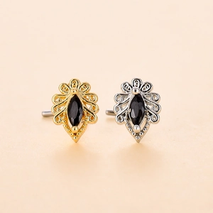 Dettaglio di piercing al naso a cuore stile boho con zircone nero in oro e argento lucido