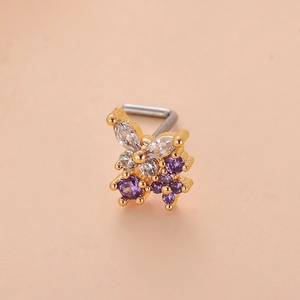 Vue détaillée d'un piercing de nez papillon doré avec des cristaux de zircone violets et blancs