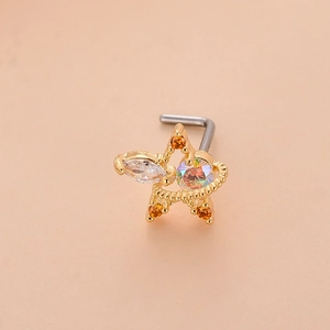 Vue macro d'un piercing nez étoile dorée en L avec zircons et bordure perlée