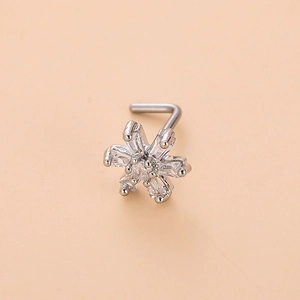 Macro shot of L-shaped nose stud with clear zircon flower design on a pink background