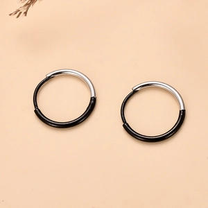 Detalle de pendientes de aro minimalistas bicolor negro y plata de acero inoxidable para mujer