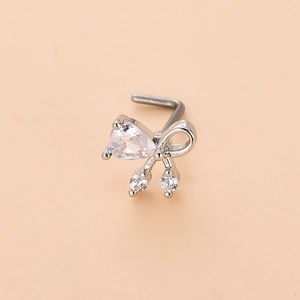 Macro shot of silver L-shaped nose stud featuring a crystal bow with a pear-shaped zircon