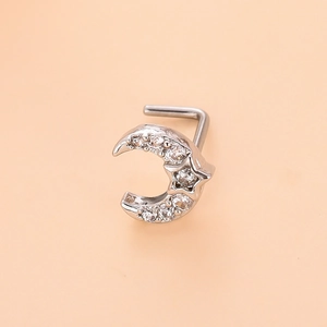 Macro view of silver crescent moon and star nose stud with sparkling zirconia stones
