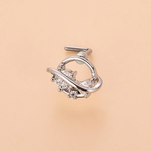 Macro detail of silver Saturn-shaped nose stud with sparkling cubic zirconia stones