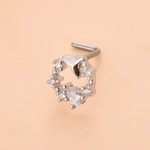 Close-up of L-shaped silver nose stud with dolphin tail design and micro-pave zircons
