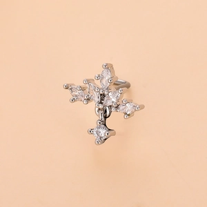 Macro shot of a polished stainless steel cross nose stud with sparkling zircon stones