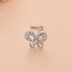 Détail macro du piercing nez en L avec motif papillon serti de zircones brillants