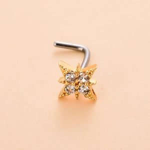 Close-up of golden L-shaped nose stud featuring a four-pointed star with clear cubic zirconia
