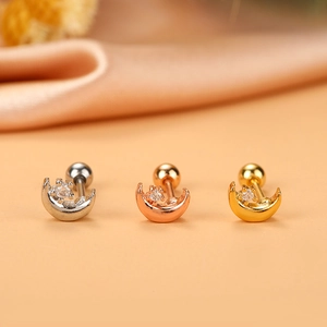 Macro view of three steel moon helix studs with zircon in silver, rose gold and gold