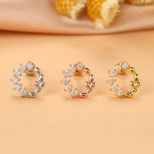 Dettaglio di orecchini a fiore in argento, oro e oro rosa con cristalli brillanti