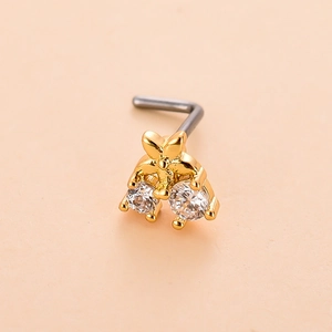 Macro shot of gold floral L-shaped nose stud with shimmering zircon stones and steel hook