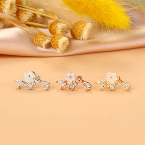 Dettaglio di orecchini a fiore per cartilagine in argento, oro e oro rosa con zirconi