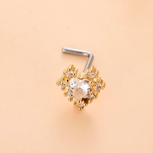 Détail macro du piercing de nez doré en forme de cœur orné de cristaux de zircone