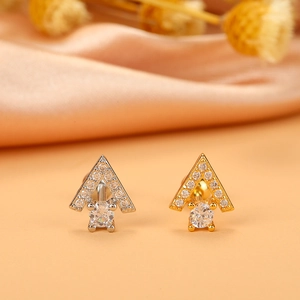Macro view of gold and silver geometric arrow stud earrings with pavé set zircon stones