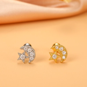 Macro shot of 16G stainless steel moon and star cartilage earrings with sparkling cubic zirconia